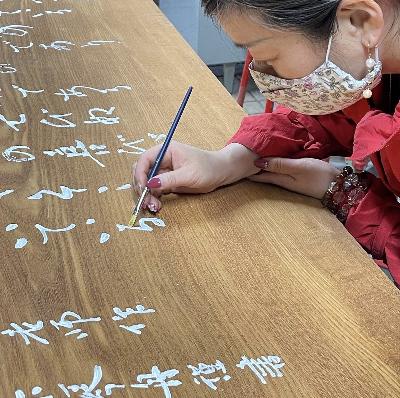 扁額の文字を筆で整える工程